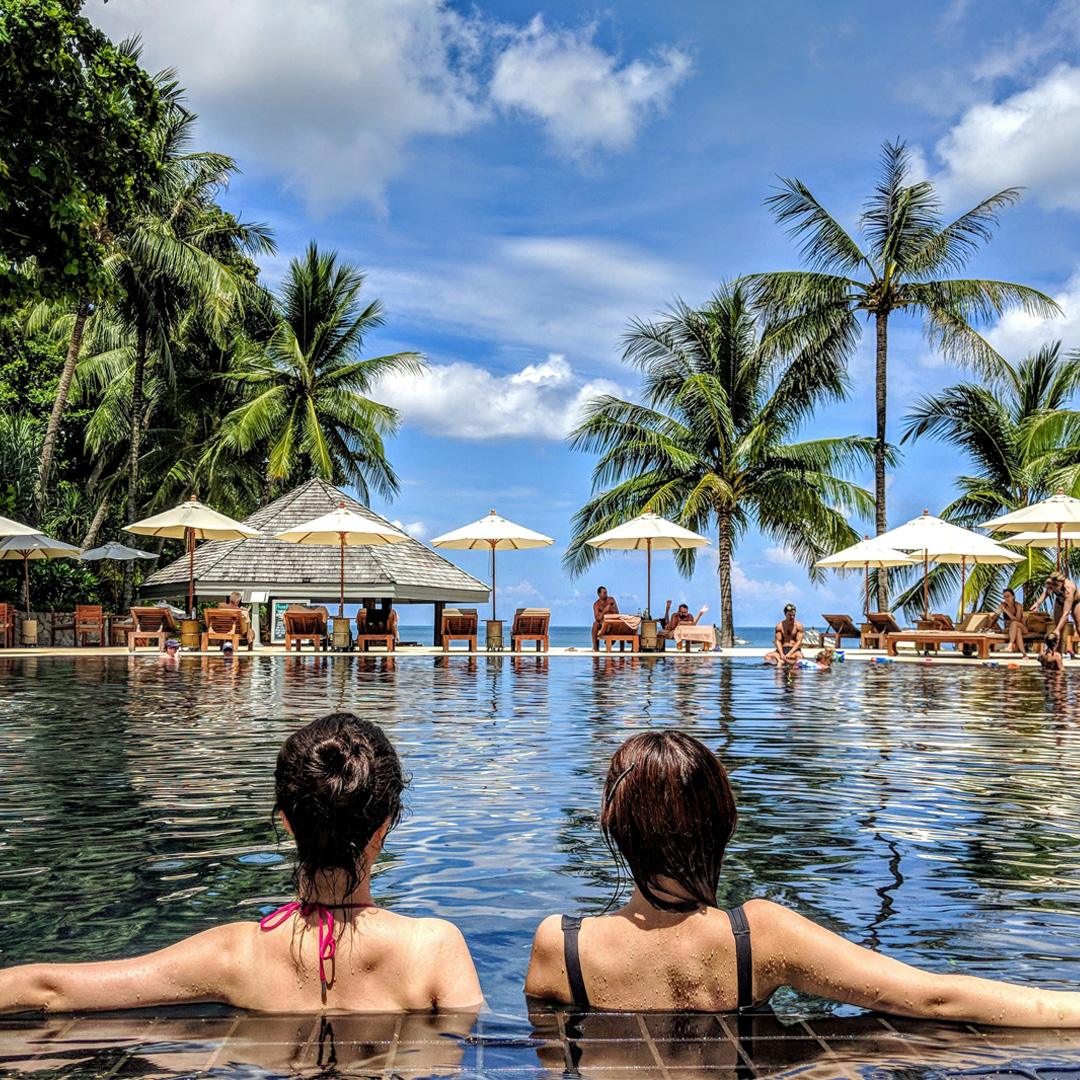 Two best friends sitting in a pool during their vacation tour and travel