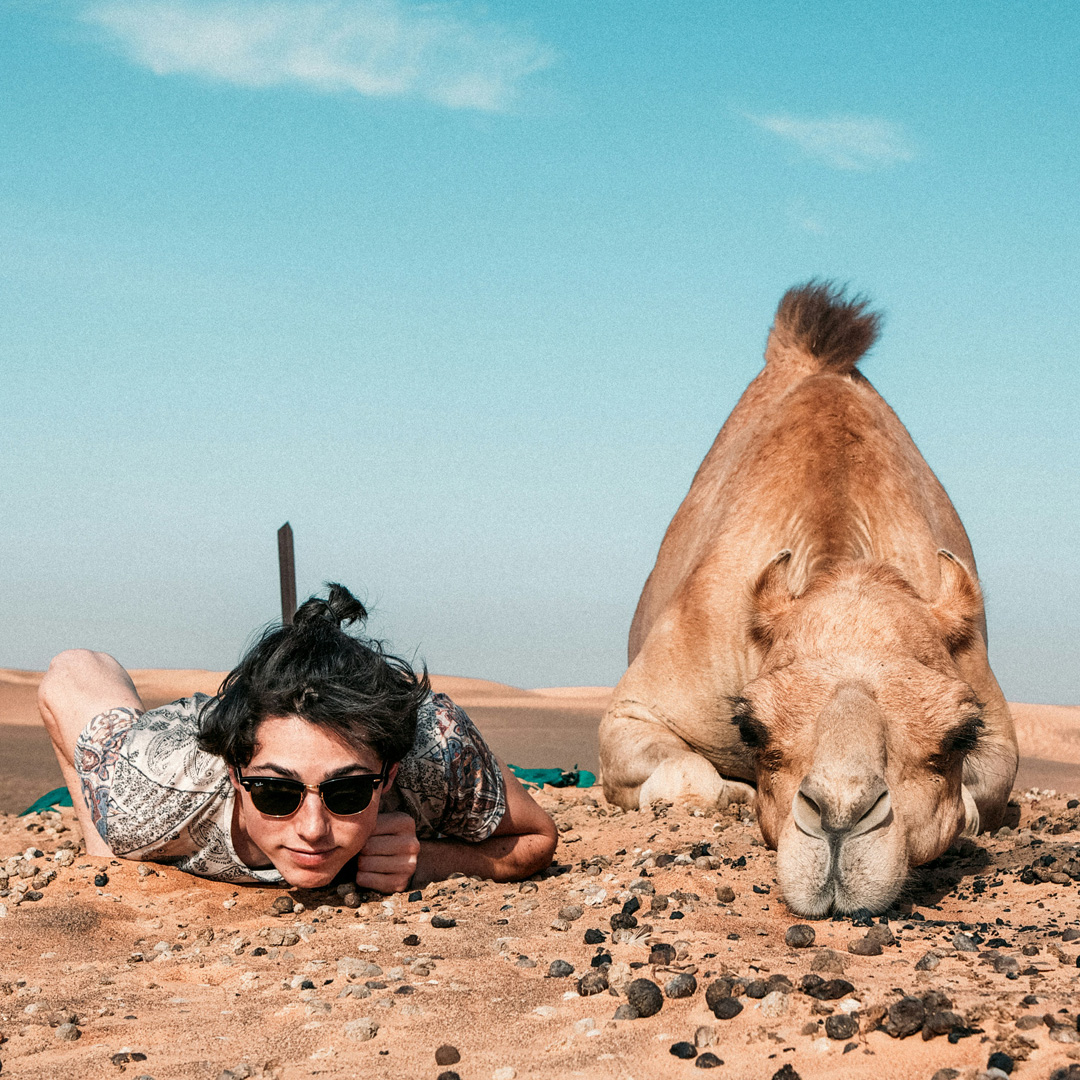 A man and a camel facing camera during his vacation tour and travel