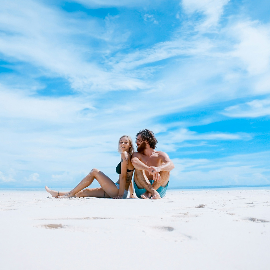 A couple sitting on the beach during their vacation tour and travel