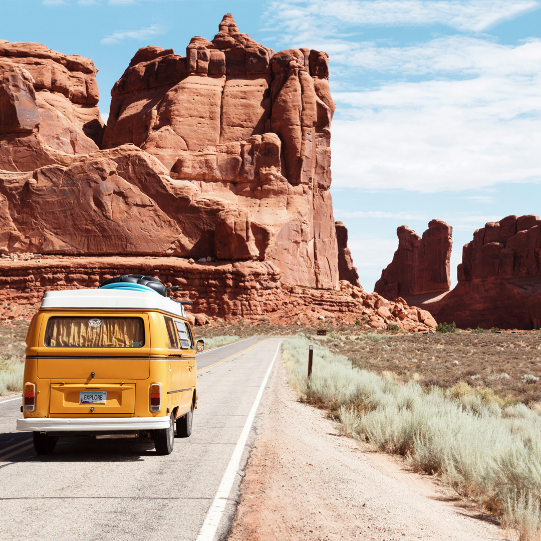 A yellow car on the way to a vacation tour and travelling across mountains