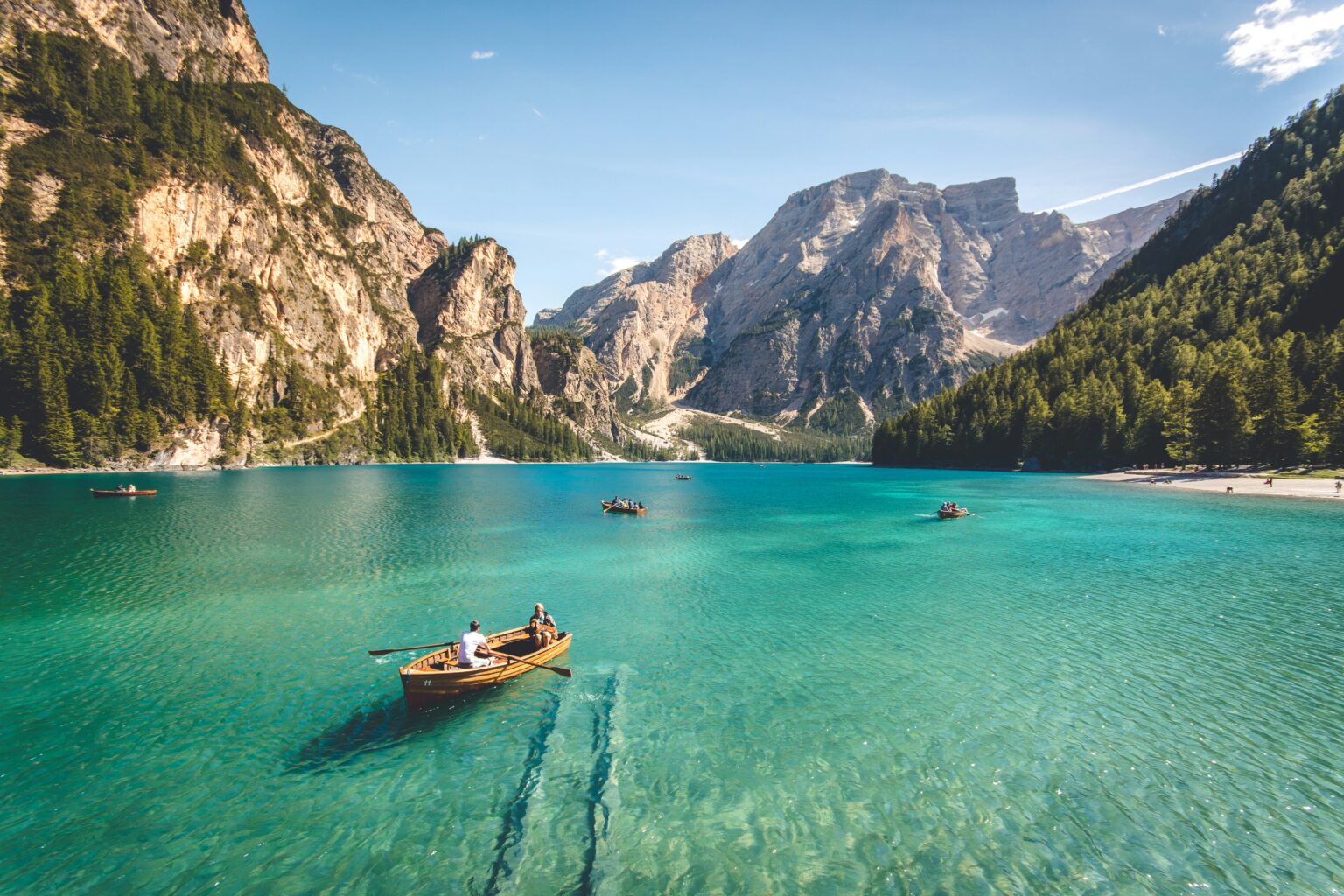 A vacation tour and travel spot with a boat in the middle of the lake surrounded by mountains